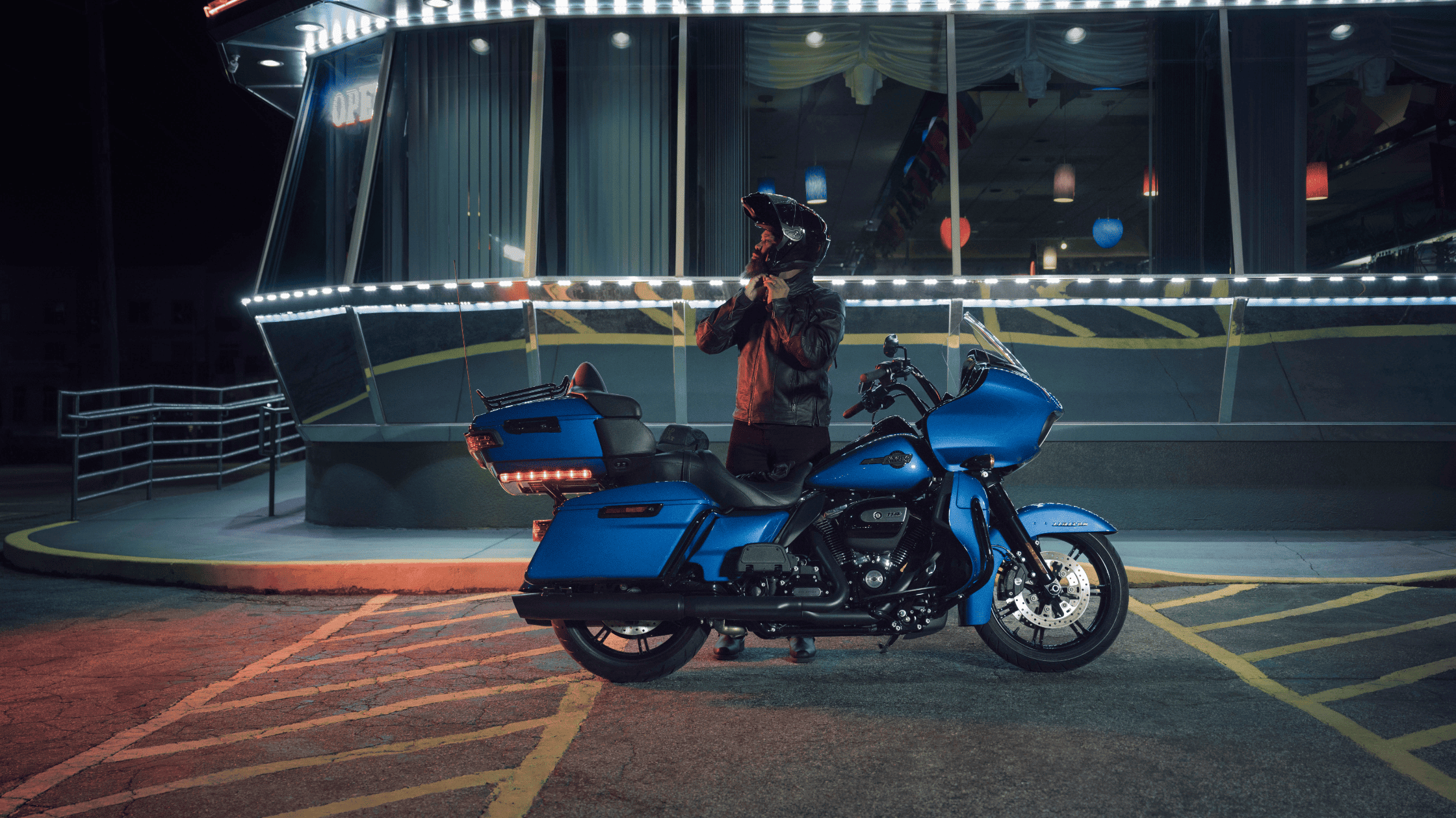 A sleek black 2024 Harley-Davidson® Road Glide® Limited parked in an urban parking structure setting