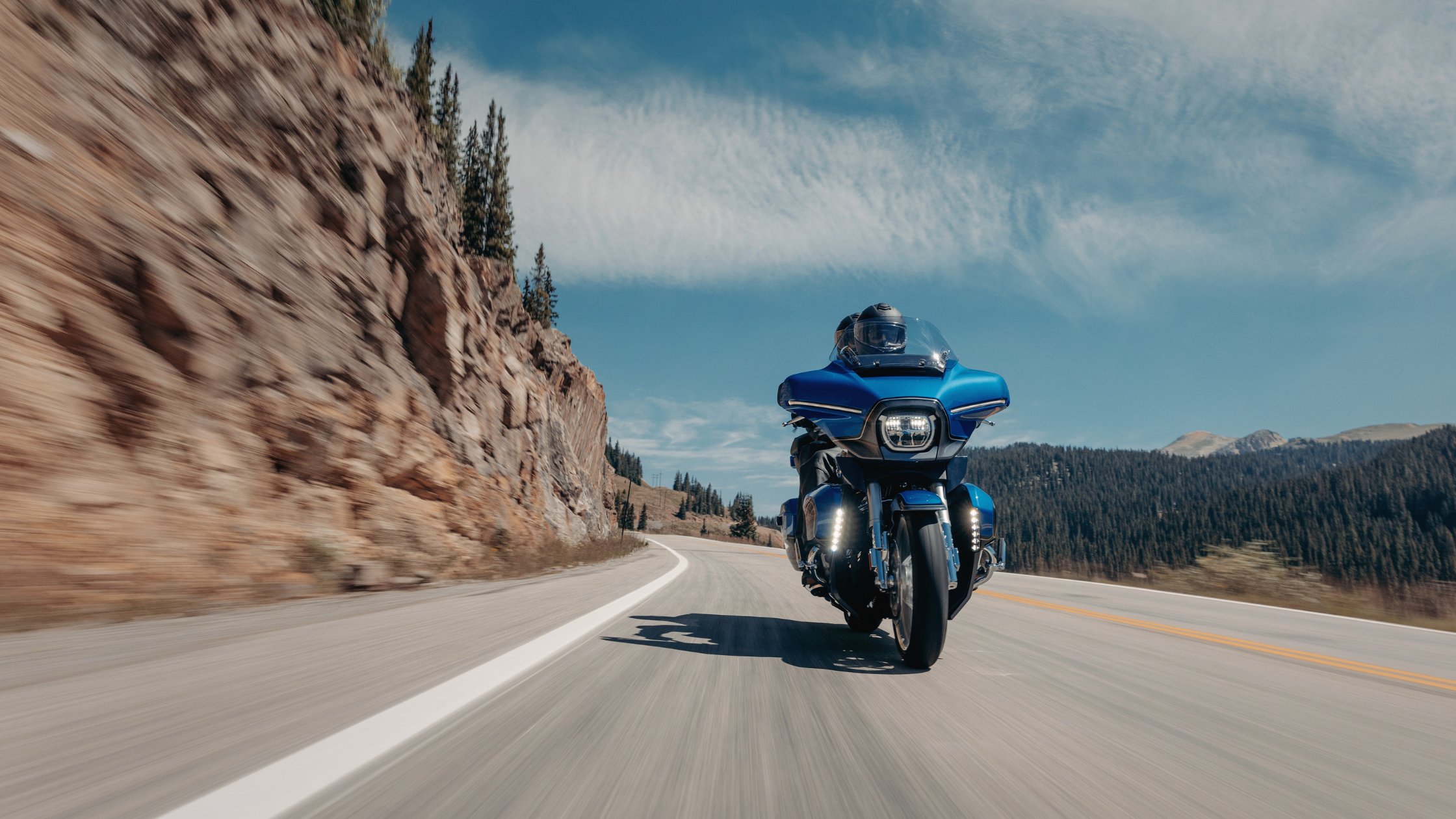 Front view of blue 2026 Harley-Davidson® CVO™ Street Glide® Limited cruising mountain highway