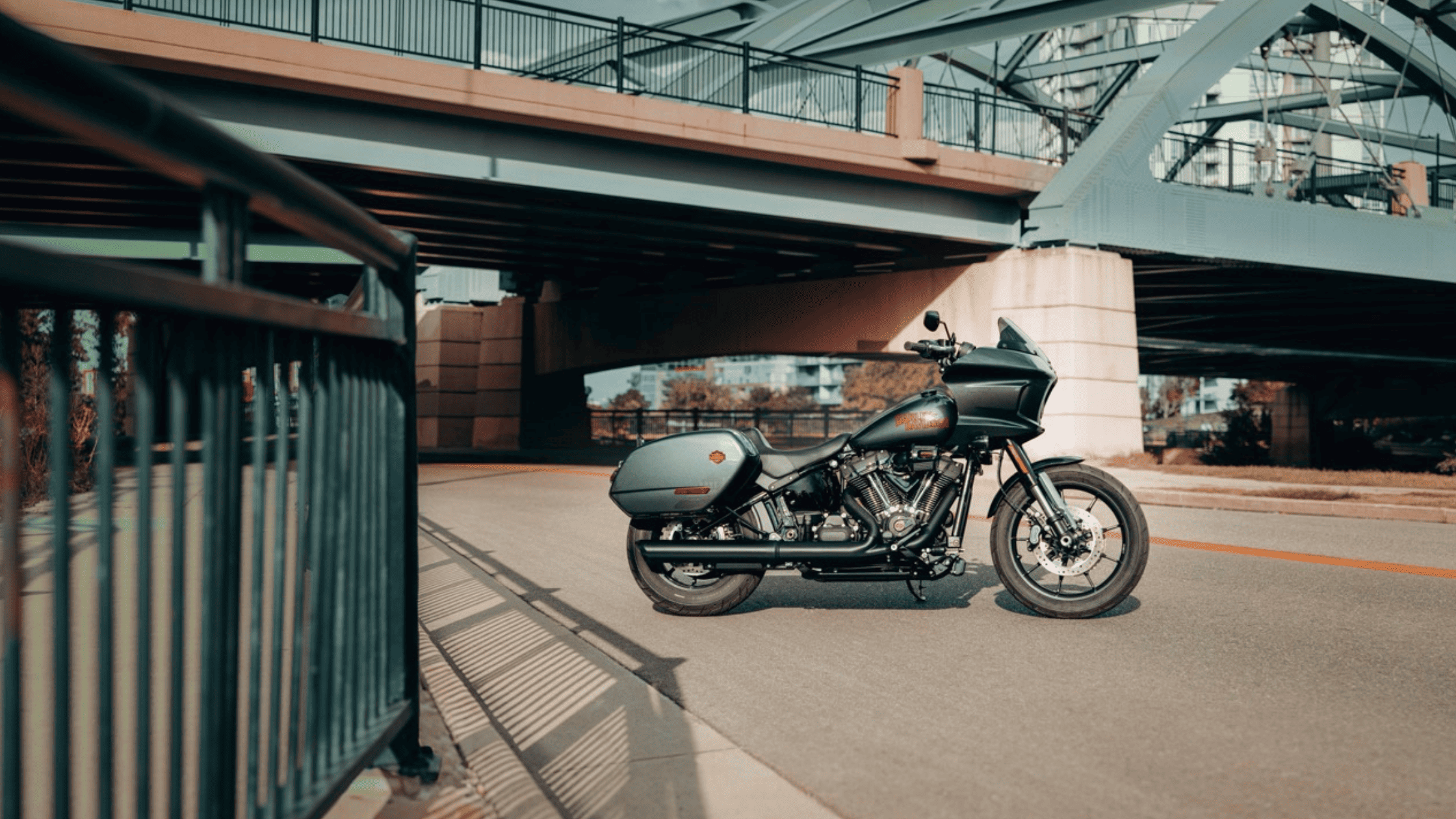 2025 H-D® Low Rider® ST in sleek dark finish with saddlebags parked beneath city bridge